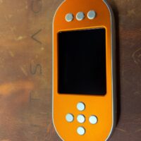 SeedSigner+ Premium in an orange anodised case with silver buttons