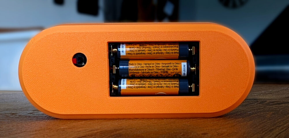 Rear battery compartment with three AAA batteries